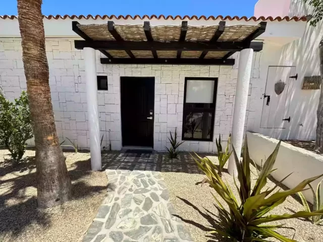 casita-3-exterior-entrance-lejos-de-todo Casita 3 exterior entrance with stone walkway and palm tree at Lejos de Todo