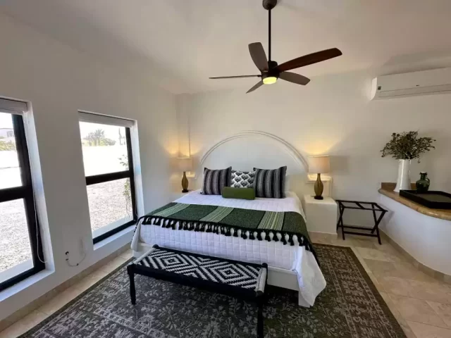 casita-3-king-bedroom-lejos-de-todo Casita 3 king bedroom with green bedding and bedside lamps at Lejos de Todo