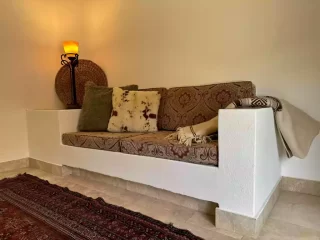 Casita 4 living area with built-in sofa and patterned cushions at Lejos de Todo