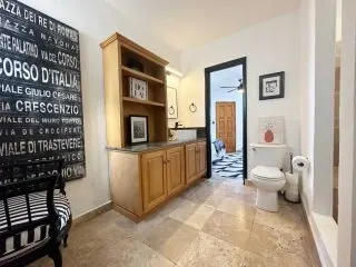 Bathroom vanity and toilet with wood cabinetry at Lejos de Todo