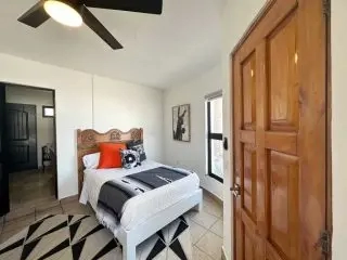Bedroom with four-poster bed and wood door at Lejos de Todo