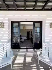 Casita 6 covered patio entrance with white outdoor chairs and glass doors