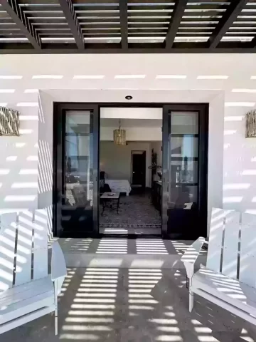 Casita 6 covered patio entrance with white outdoor chairs and glass doors