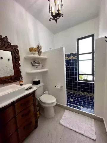 casita-7-bathroom-blue-tile-shower Casita 7 bathroom with blue tile walk-in shower, carved wood vanity, and decorative mirror